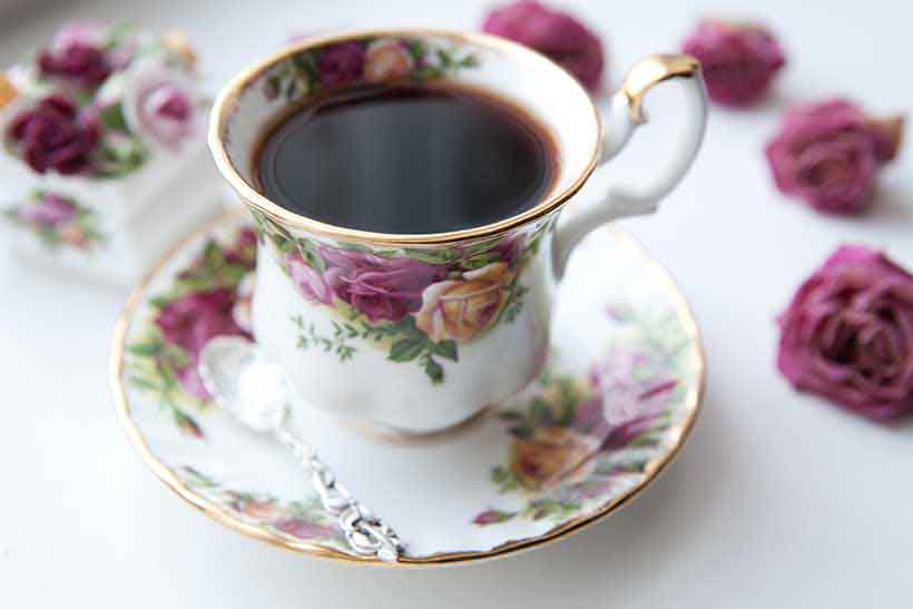 Taza de té negro en taza china con platillo. Taza de té negro.