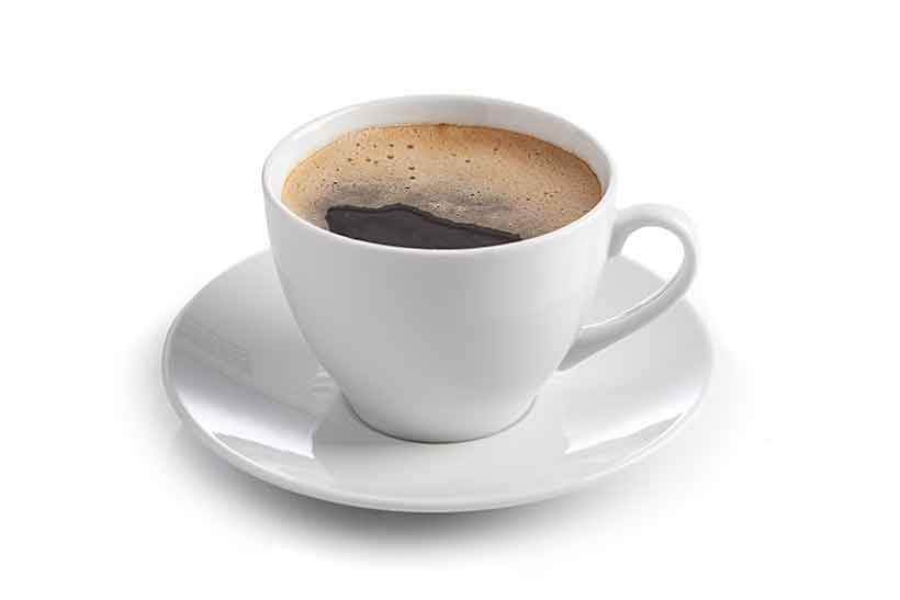 Taza de Café Negro (Americano). Café negro caliente en taza blanca con platillo.