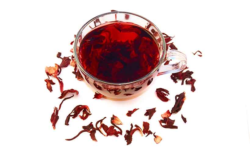 Té de hierbas de hibisco en vaso de vidrio con pétalos de flores. Vaso de té de hibisco rico en polifenoles.
