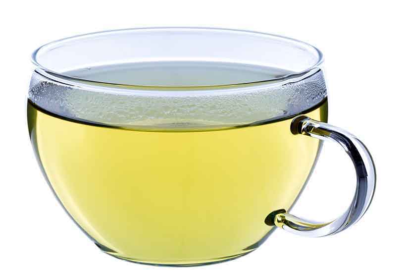 Una taza de té verde japonés en una copa de cristal. Té verde en una taza de cristal.