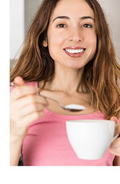 Mujer que agrega edulcorante a su café.