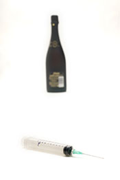 Botella de alcohol y jeringa - El alcohol es un tema de drogas.