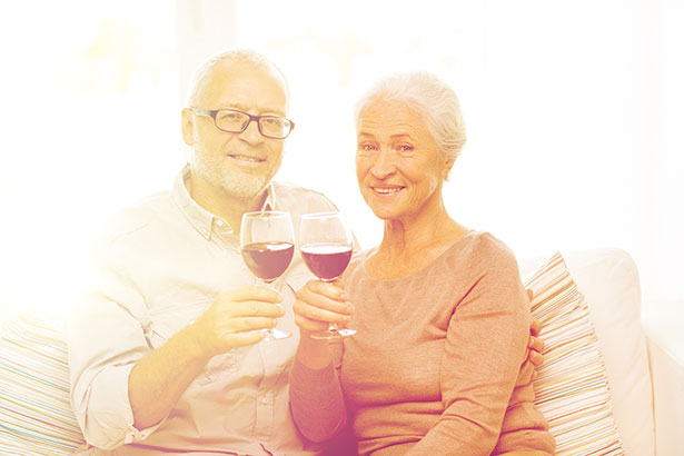Pareja de ancianos bebiendo una copa de vino tinto.