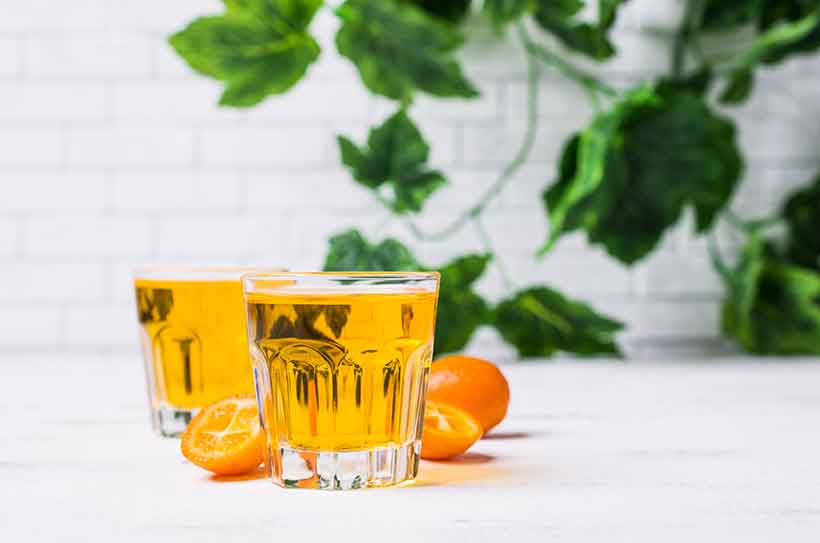 Imagen que muestra dos Kumquat medio vaso de cócteles.
