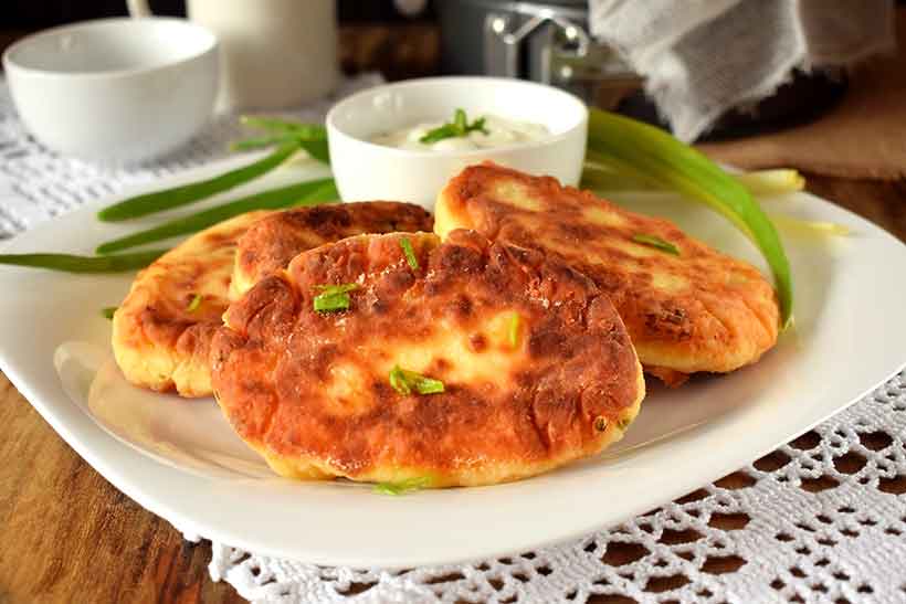 Panqueques de queso crema en un plato con salsa de crema agria.