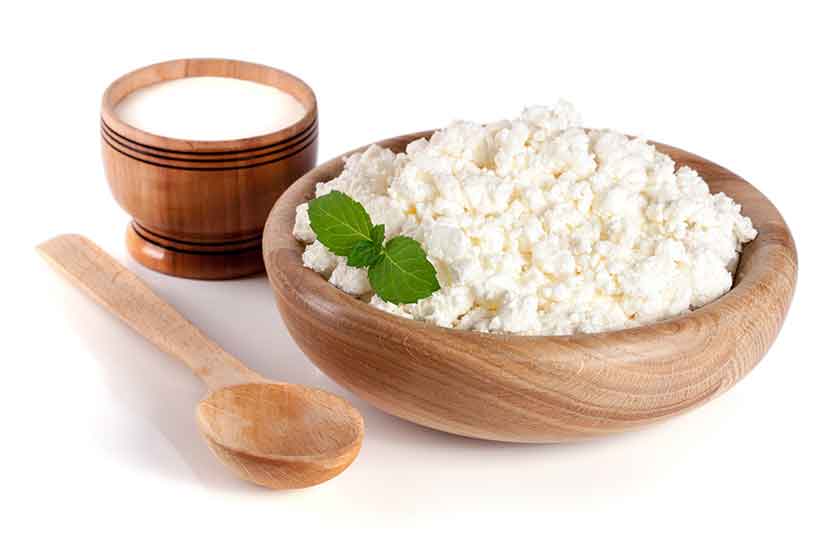 Cuenco de madera que contiene queso cottage - Producto lácteo fresco.