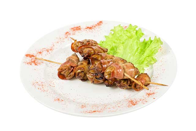Palitos de kebab de pollo doblado con tocino.