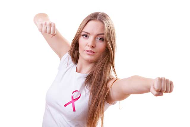 Mujer con un lazo rosa que representa la lucha contra el cáncer.