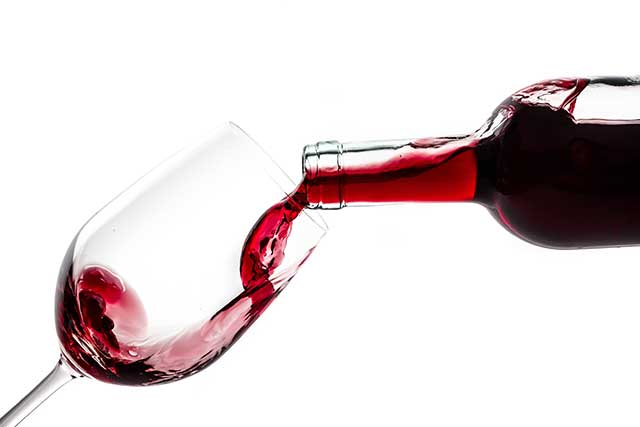 Verter Vino Tinto De Una Botella En Un Vaso.