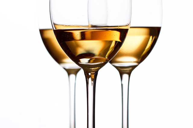 Tres copas de vino blanco.