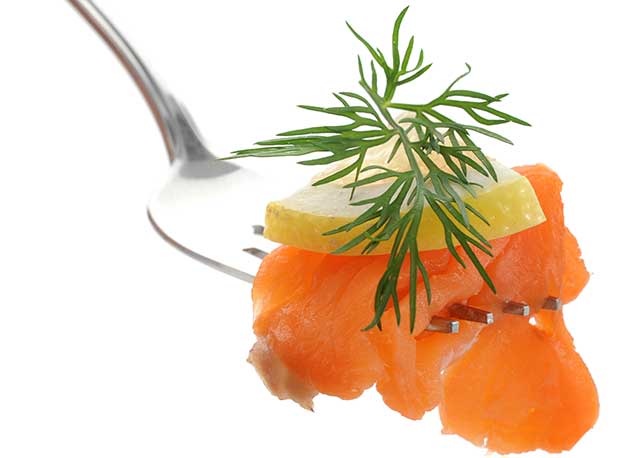 Salmón ahumado con limón en tenedor.