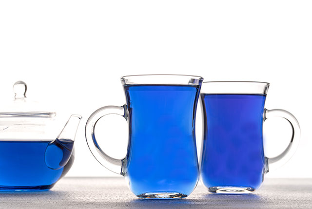 Té de flor de libra de mariposa en tetera de vidrio y dos vasos.