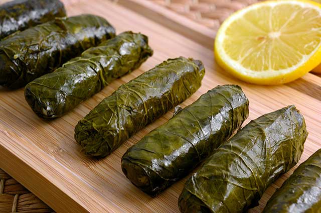 Hojas De Parra Rellenas (Dolma) Sobre Una Tabla De Madera.