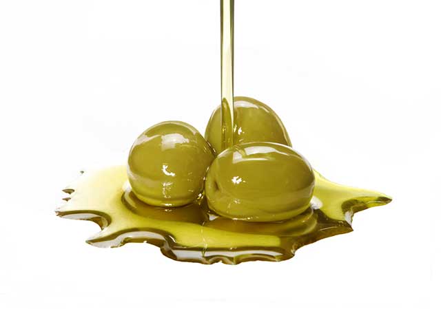Aceite de Oliva Virgen Extra Derramado sobre Aceitunas Verdes.