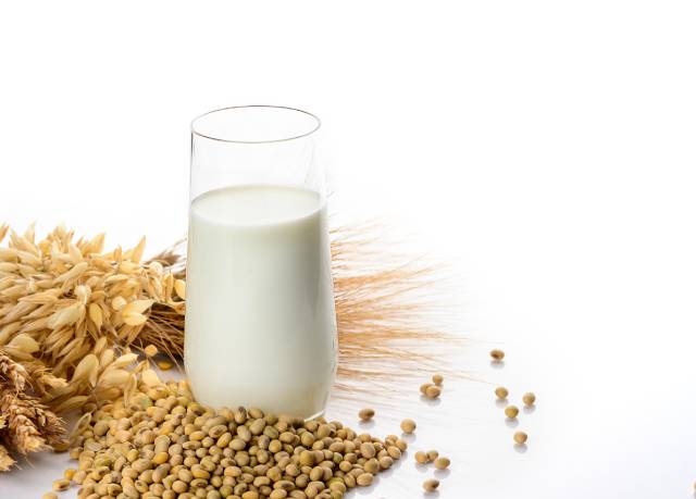 Vaso de leche de soja junto a la soja.