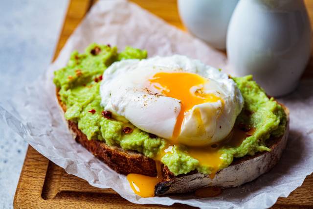 Huevos escalfados sobre tostadas de aguacate.